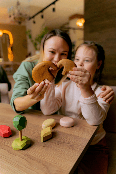 a person and child holding wooden toys